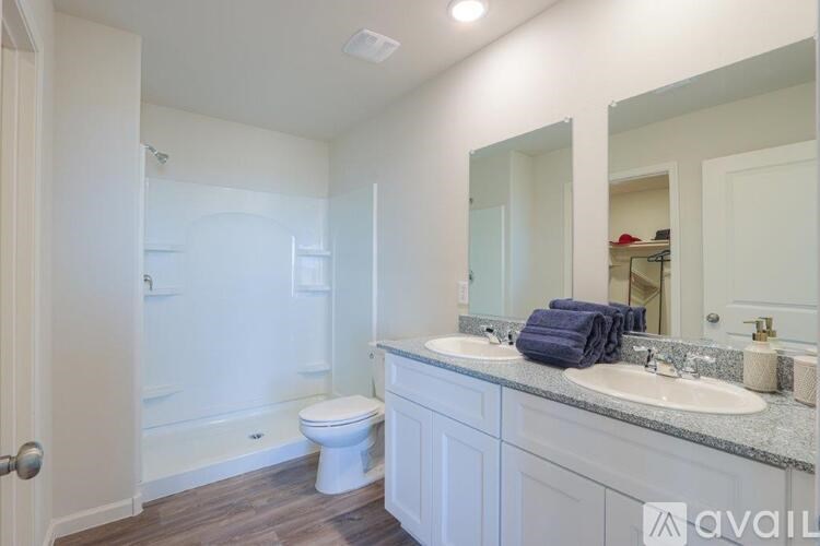 A bathroom with a toilet, sink, and mirror.