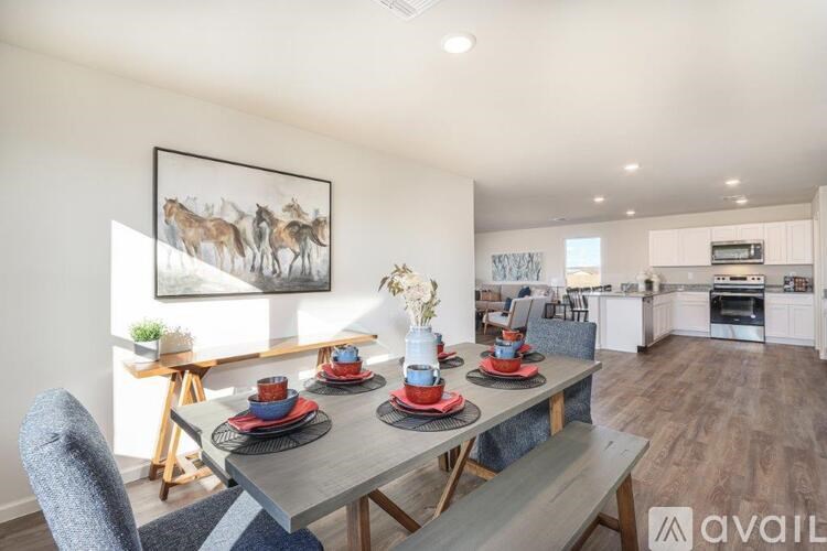 A modern dining room with a grey table set for four.