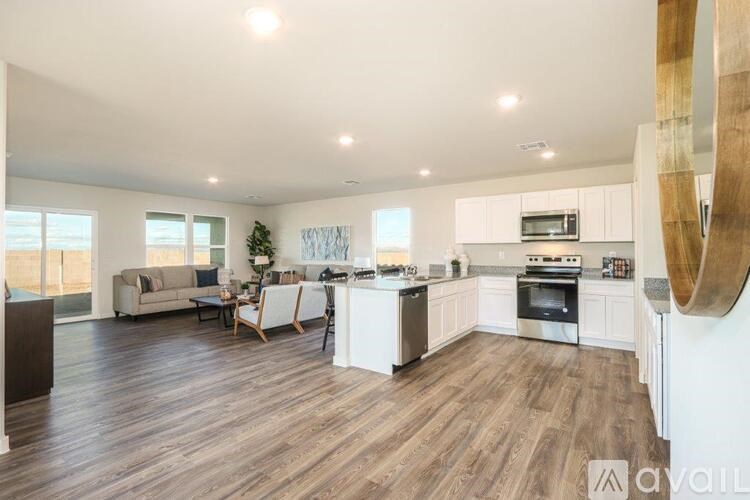 A modern kitchen with white cabinets and a wooden floor.