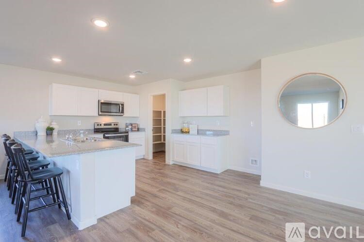 A kitchen with white cabinets and a wooden floor.
