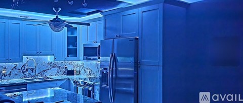 A kitchen with a refrigerator and a ceiling fan.