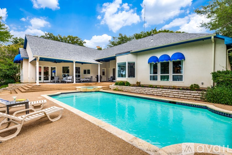 A house with a pool in front of it.
