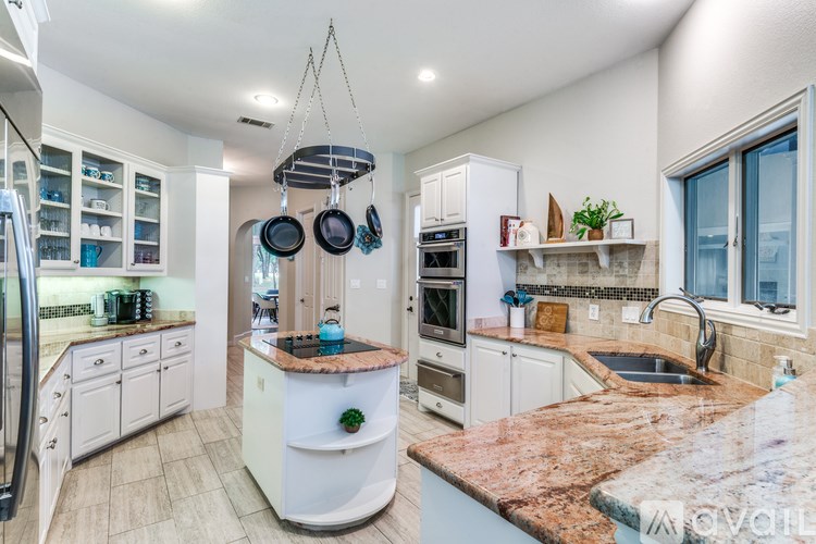 A kitchen with a granite countertop and stainless steel appliances.