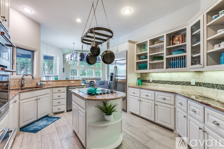 A kitchen with a center island and a hanging pot rack.
