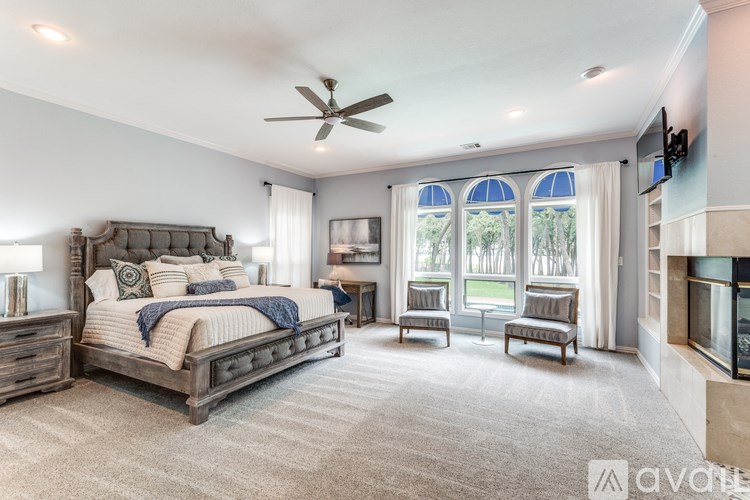 A bedroom with a large bed, a TV, and a fireplace.