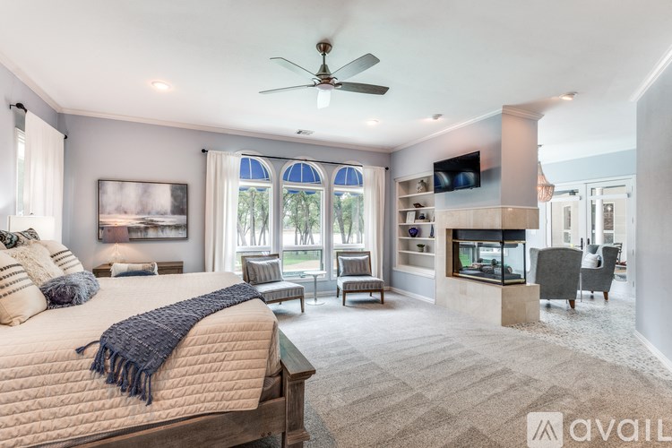 A bedroom with a large bed and a ceiling fan.