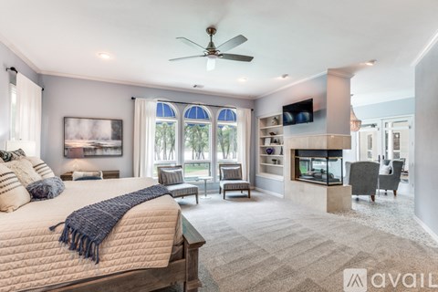 A bedroom with a large bed and a ceiling fan.