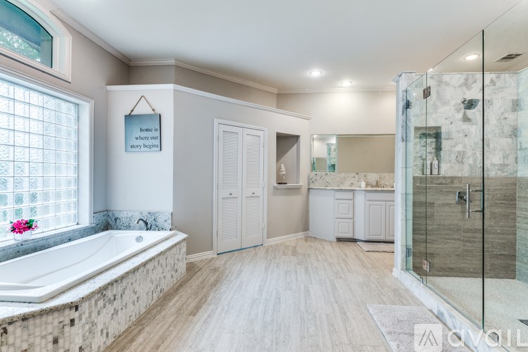 A bathroom with a tub, sink, and shower.