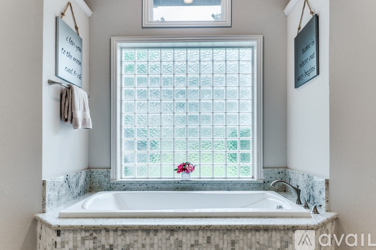 A bathroom with a tub and a window with a grid pattern.