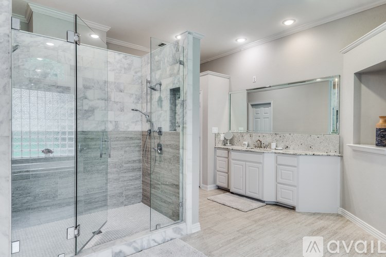 A bathroom with a walk-in shower and a vanity with a mirror.