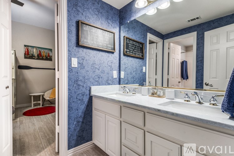 A bathroom with a blue wallpaper and a white vanity.