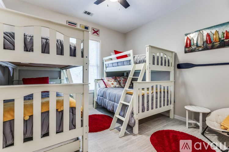 A bedroom with bunk beds and a red rug.