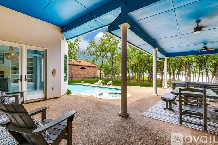 A patio with a pool and a table and chairs.