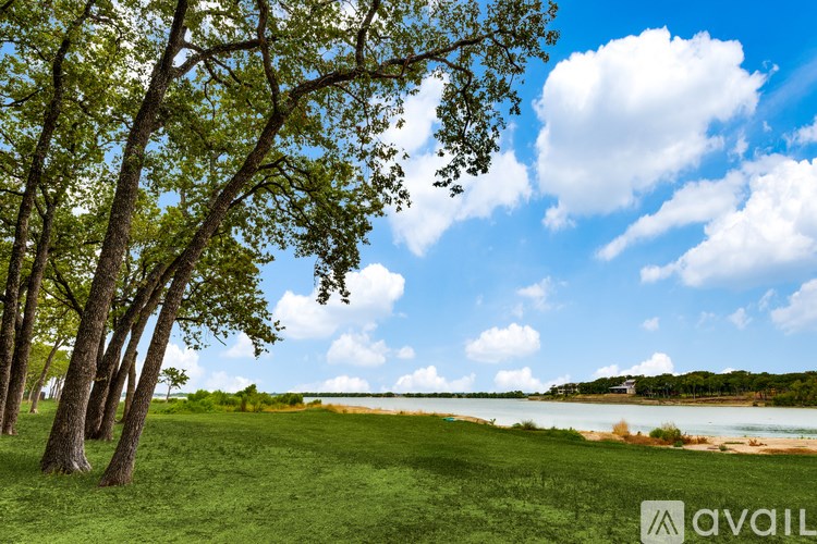 A beautiful landscape with a lake, trees, and a clear sky.