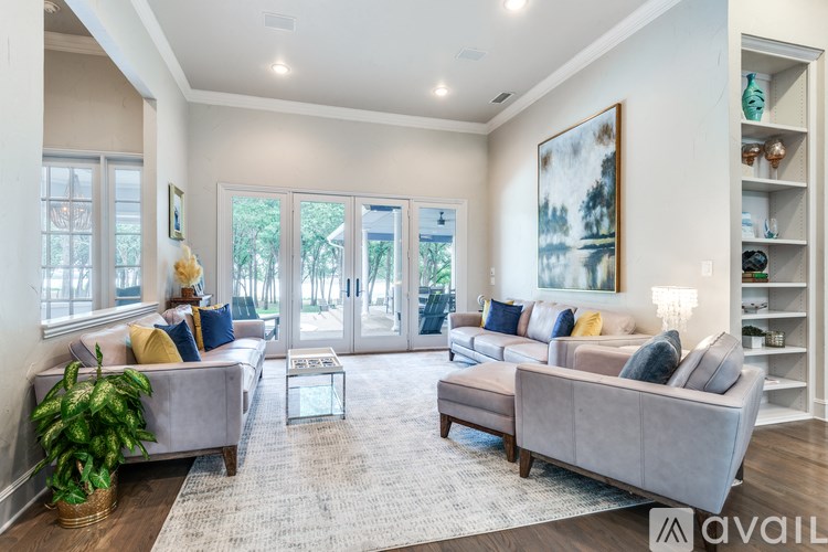 A living room with a grey couch, a coffee table, and a painting on the wall.