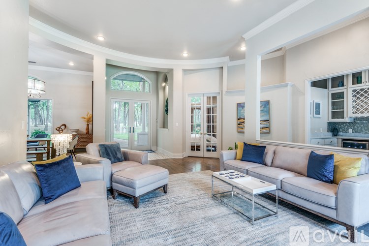 A living room with a white couch and a glass coffee table.