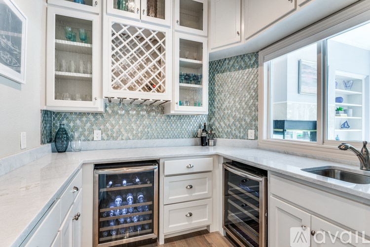 A kitchen with white cabinets and a tile backsplash.