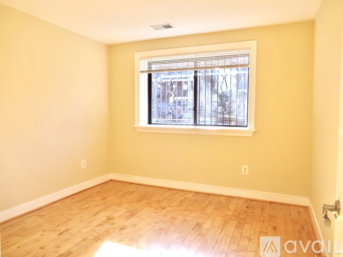 A room with a window and wooden flooring.