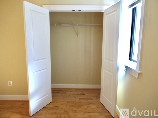A room with a white door and a wooden floor.