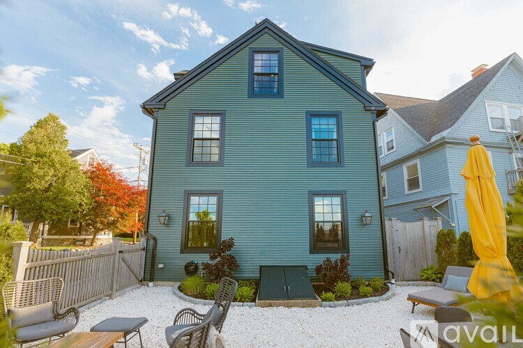 A blue house with a patio and a yellow umbrella.