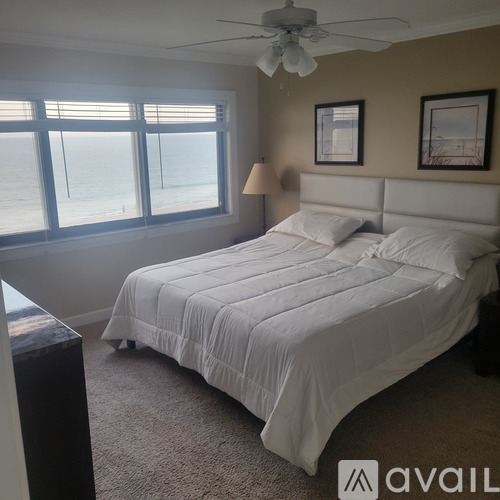 A bedroom with a large bed and a ceiling fan.