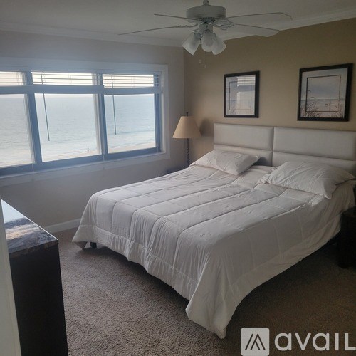 A bedroom with a large bed and a ceiling fan.
