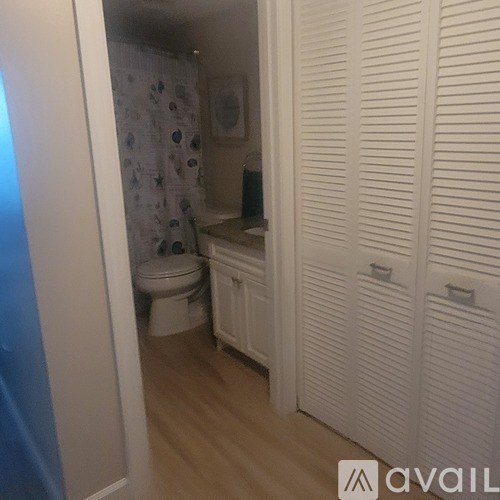 A small bathroom with a toilet, sink and a shower curtain.