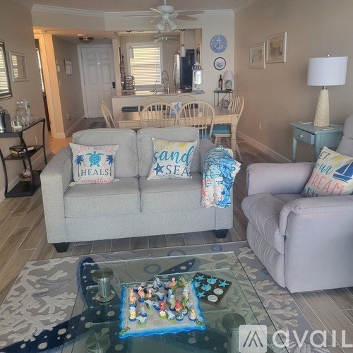 A living room with a couch, a chair, a coffee table, and a lamp.