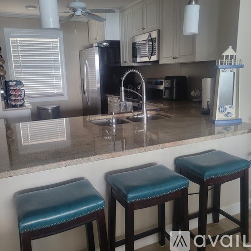 Two blue stools are placed in front of a kitchen counter.