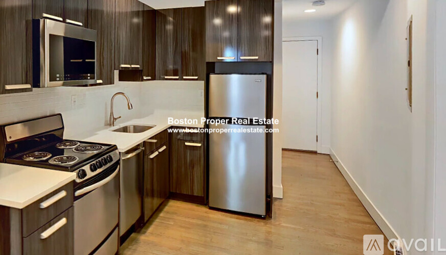 A modern kitchen with wooden cabinets and stainless steel appliances.