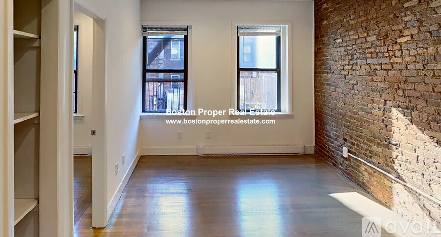 A room with a brick wall and a window.