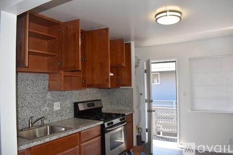 A kitchen with wooden cabinets and a granite countertop.
