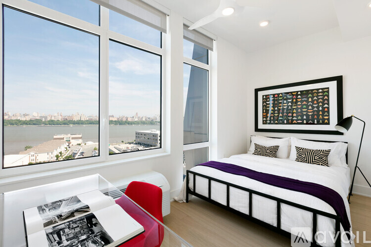 A bedroom with a large bed and a red chair.