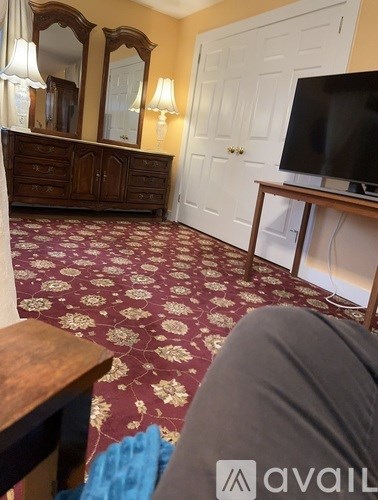 A living room with a television and a wooden cabinet.