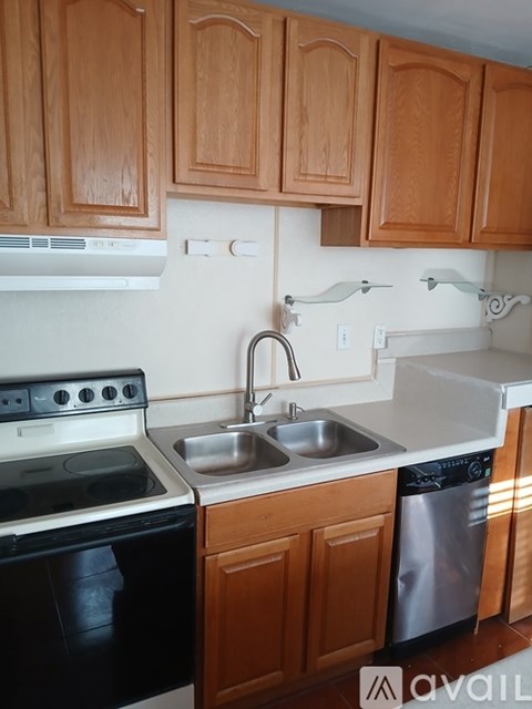 A kitchen with wooden cabinets and a black stove top oven.