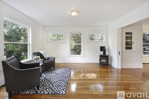 A living room with a fireplace and a rug on the floor.