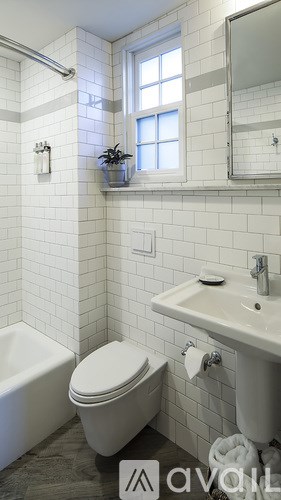 A white bathroom with a toilet, sink, and tub.