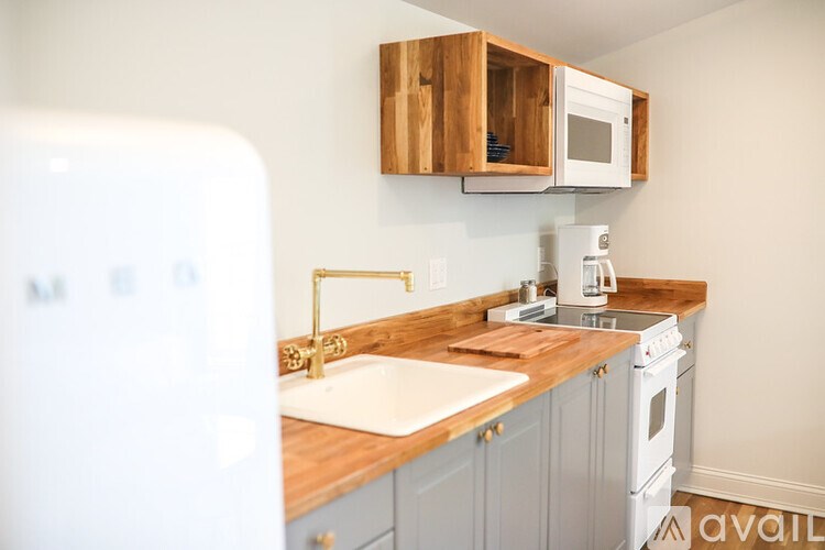 A kitchen with a white fridge, a white sink, a white stove and a white microwave.
