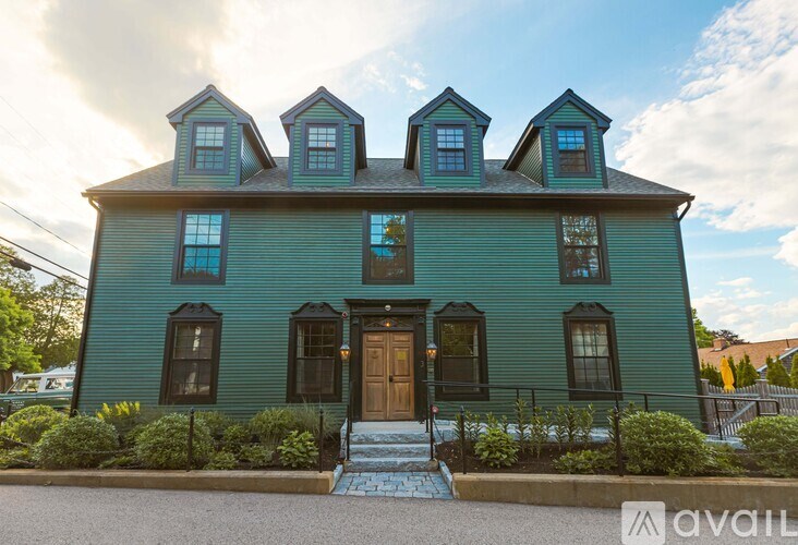 A green house with a brown door and windows.