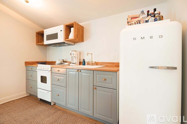 A kitchen with a white refrigerator and wooden cabinets.