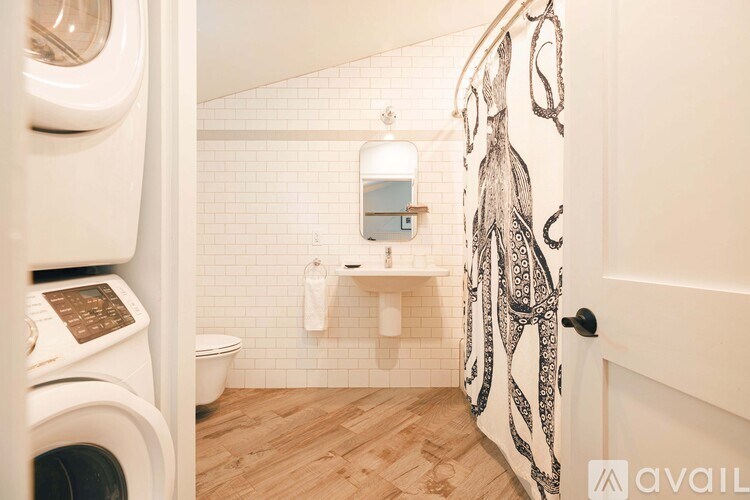 A bathroom with a washing machine and a shower.