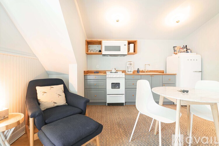 A kitchen with a blue chair and a white table.