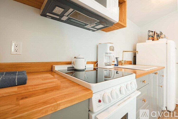 A modern kitchen with a white stove top oven and wooden countertops.