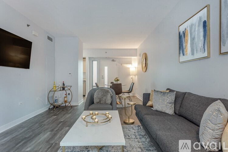 A modern living room with a grey sofa and a white coffee table.