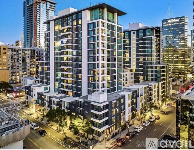 A modern multi-story building with a lot of windows is lit up at night.