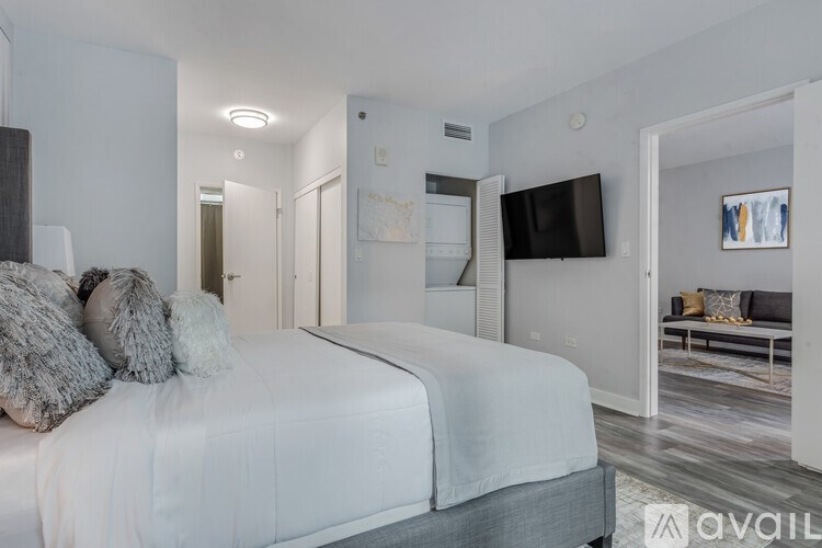 A bedroom with a large bed and a television on the wall.