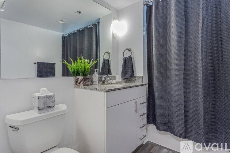 A white toilet sits next to a white cabinet with a mirror above it.