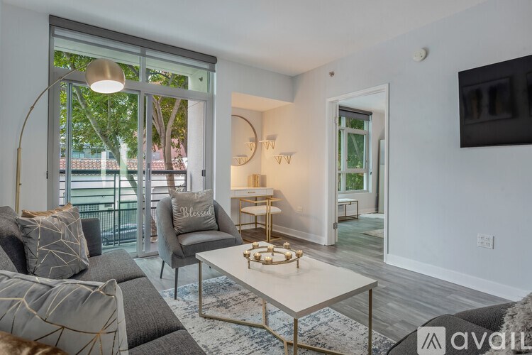 A living room with a grey couch and a white coffee table.