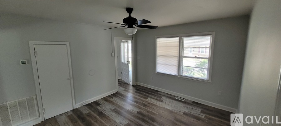 A room with a ceiling fan and a window.
