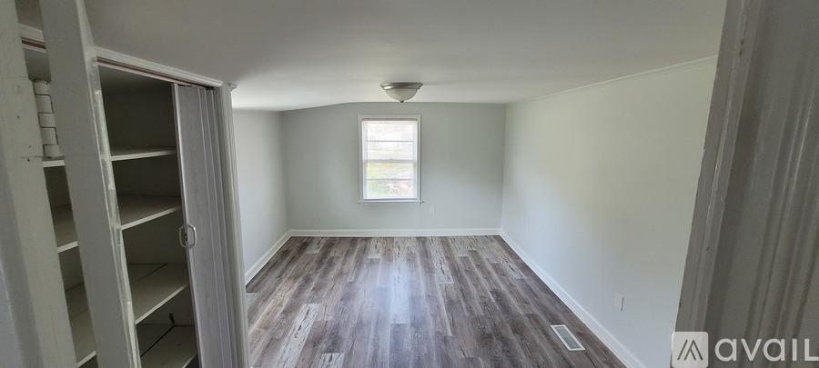 A room with wooden floors and a window.